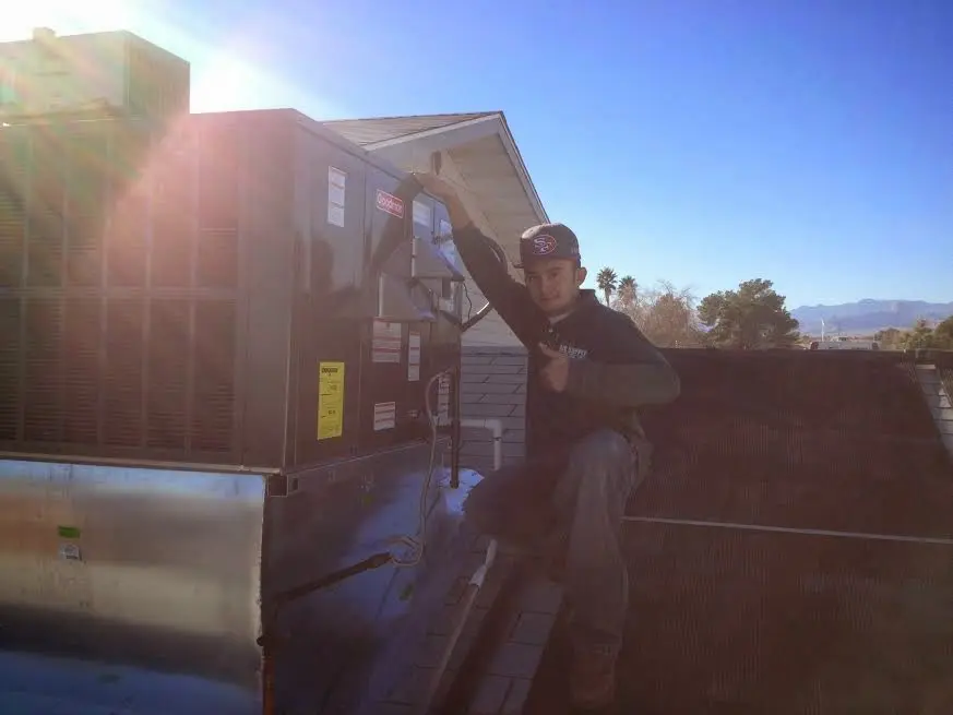 HVAC technician performing Air Duct Cleaning on a rooftop unit in Northlake