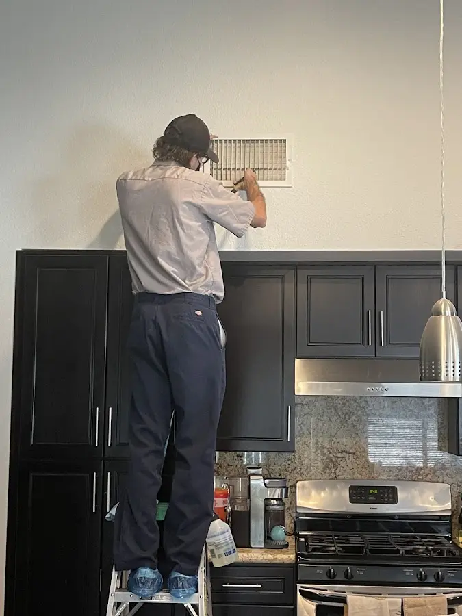 Technician inspecting an air vent during HVAC service in Northlake